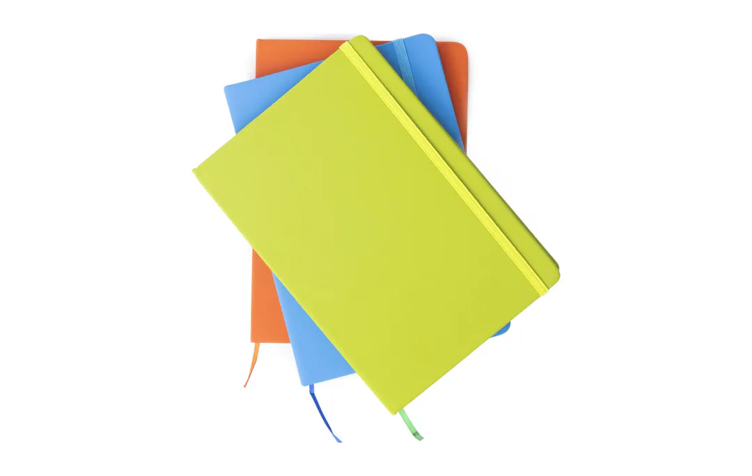 Hard-cover bound books in lime, blue and orange